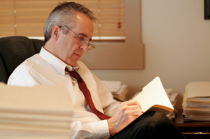 Man reading documents at desk.
