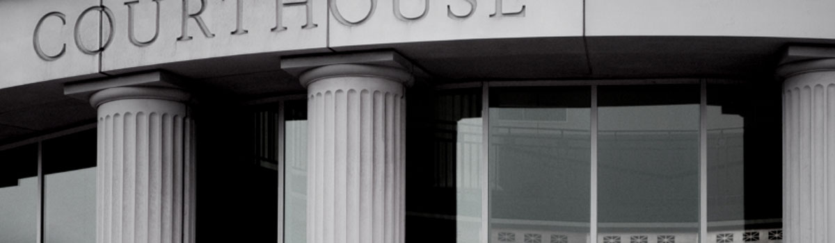 Close-up of courthouse pillars and part of the building's sign.